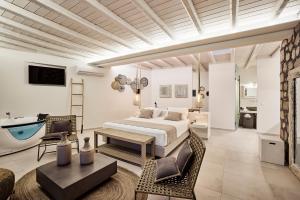 a hotel room with a bed, table and chairs at Nirome Luxury Suites in Adamantas
