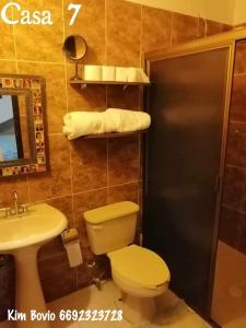 a bathroom with a toilet and a sink and a mirror at Casa 7 in Mazatlán