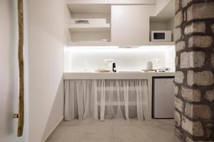 a kitchen with white walls and a counter at Nirome Luxury Suites in Adamantas