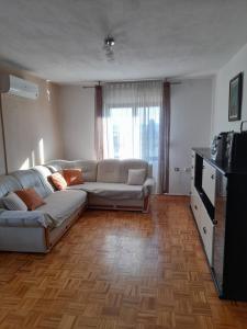 sala de estar con sofá y TV en Apartment Mario, en Zadar