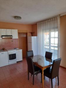 una cocina con mesa y sillas y una cocina con electrodomésticos blancos. en Apartment Mario, en Zadar