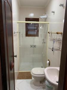 a bathroom with a shower and a toilet and a sink at Casa de Temporada Praia Juquehy in Juquei