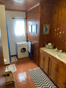 a bathroom with a sink and a washing machine at Casa da Costa in Madalena