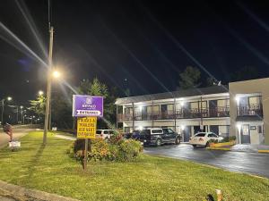 un panneau de rue devant un bâtiment la nuit dans l'établissement Bravo Inn, à Johnson City