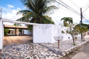 un bâtiment blanc avec un palmier derrière dans l'établissement Cajueiro's House, à Aracaju