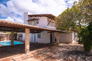 une image d'une maison avec une piscine dans l'établissement Cajueiro's House, à Aracaju