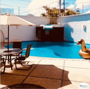 a swimming pool with a table and a duck next to it at Hotel Blue Star Cancun in Cancún