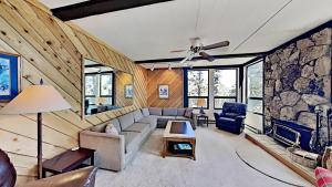 a living room with a couch and a stone wall at Great Condo With Free Shuttle to the Village! in Mammoth Lakes