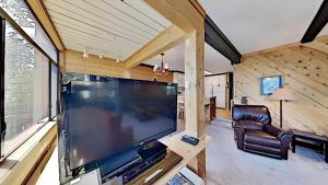 a living room with a large flat screen tv at Great Condo With Free Shuttle to the Village! in Mammoth Lakes