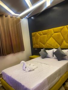 um quarto com uma cama grande e uma cabeceira amarela em Equinox em Tan-Tan Plage