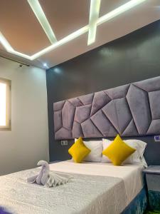 a bedroom with a large bed with a purple headboard at Equinox in Tan-Tan Plage