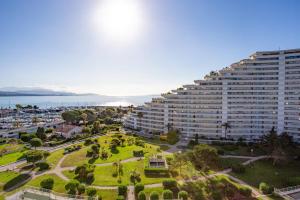 a large building with a park in front of it at Studio de la Baie des Anges - Welkeys in Villeneuve-Loubet