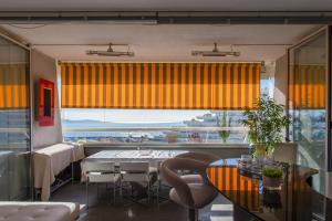 a dining room with a table and a large window at Studio de la Baie des Anges - Welkeys in Villeneuve-Loubet