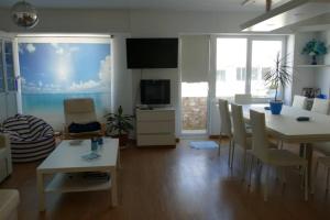 sala de estar con mesa y sillas y cocina en Piso en Santa Cristina, a 150 m de la playa, en Oleiros