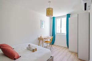 a white bedroom with a bed and a desk at Beautiful flat with balcony in the heart of Marseille - Welkeys in Marseille