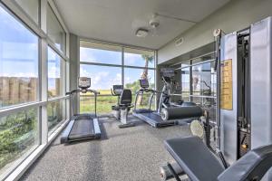 una palestra con tapis roulant ed ellittiche in una stanza con finestre di Ocean Views and Pool Access Orange Beach Condo! a Orange Beach