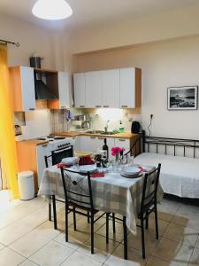 a kitchen with a table and chairs in a kitchen at Cozy Apartment Near City Center in Preveza