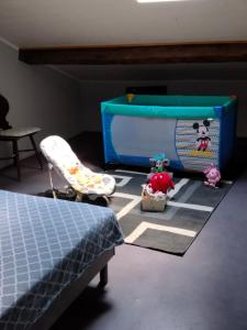 a bedroom with a bed and a table and a crib at Duplex 2 au centre de MIRECOURT in Mirecourt