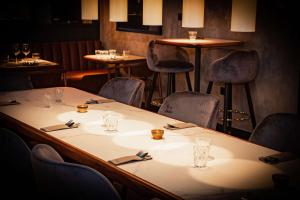 a table in a restaurant with chairs and glasses on it at Radisson Blu Hotel, Madrid Prado in Madrid