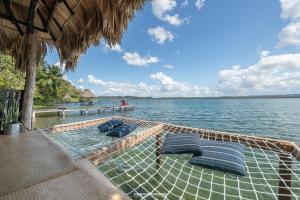 a raft with blue pillows on a boat in the water at Hotel Gringo Perdido in El Remate