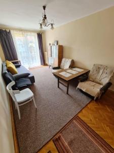 a living room with a couch and a table at Apartament Omega 250m do plaży in Giżycko