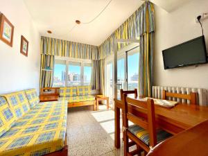 a living room with a dining table and a television at Goetten Mar in Platja d'Aro