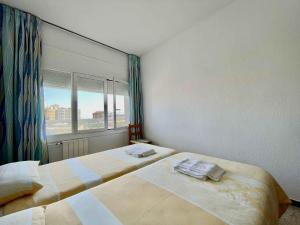 a bedroom with two beds and a window with a view at GoettenMar Platja d'Aro in Platja  d'Aro