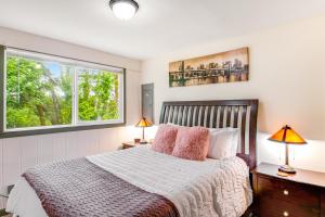 a bedroom with a bed with two lamps and two windows at Ocean Breeze & Clam Pad in Ocean Shores
