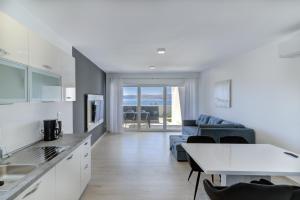 斯維尤拉伊的住宿－APARTMANI OLIMP1，厨房以及带沙发和桌子的客厅。
