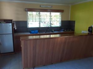 a kitchen with a counter and a refrigerator and a window at Daku Resort in Savusavu