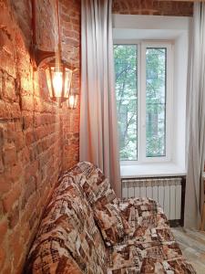 uma cama num quarto com uma parede de tijolos em Апартаменты "Антресоль" em São Petersburgo