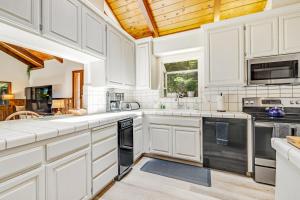 een keuken met witte kasten en zwarte apparaten bij Surfwood Getaway in Mendocino