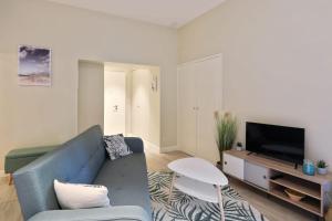 un soggiorno con divano blu e TV di Appartement des Anges - Welkeys a Cannes