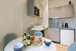 a kitchen with a table with drinks and food on it at Appartement des Anges - Welkeys in Cannes