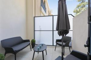 a patio with chairs and an umbrella and a table at Appartement des Anges - Welkeys in Cannes