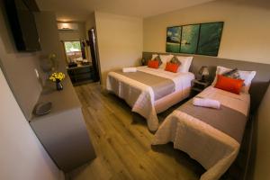 a hotel room with two beds and a tv at POUSADA ATALAIA NORONHA in Fernando de Noronha