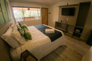 a bedroom with a large bed and a television at POUSADA ATALAIA NORONHA in Fernando de Noronha