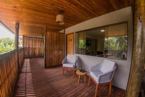 a porch with two chairs and a table on a deck at POUSADA ATALAIA NORONHA in Fernando de Noronha
