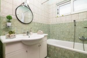 a bathroom with a sink and a tub and a mirror at Villa Zakynthian treasure in Vanáton +21 photos