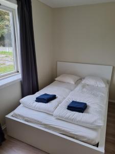 a white bed with two blue towels on it at Vollvaagen Apartments Smøla, boat included in Smøla