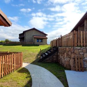 a fence and a stone wall next to a house at Villas, El Mirador de Isla in Isla