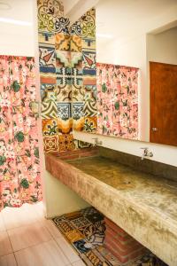 Casa Del Pozo Boutique Hostel في كارتاهينا دي اندياس: حمام مع بلاط ملون على الجدران