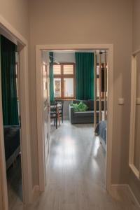 uma sala de estar com cortinas verdes e um sofá em Apartamenty Długa 6 em Bydgoszcz