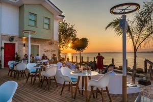a restaurant with tables and chairs on a deck with the ocean at Carpe Diem Boutique Hotel - Adults Only in Side