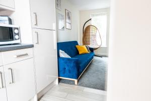 a blue couch in a kitchen with a microwave at ✪ LEISURE/BUSINESS ✪ 1 Bedroom Apt , Free Parking in Swansea