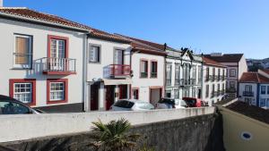 un gruppo di edifici e auto parcheggiate su una strada di Sunrise - Casa Sao Joao - 4 Star Tourist Apartments ad Angra do Heroísmo