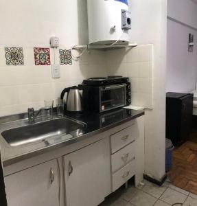 una cucina con lavandino e forno a microonde di Greta Apartment II a Mendoza