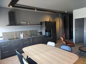 uma cozinha com uma mesa de madeira e cadeiras num quarto em Boutique by the harbour - Apartments 207 Akureyri em Akureyri