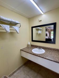 a bathroom with a sink and a mirror at Economy Motel in Galloway