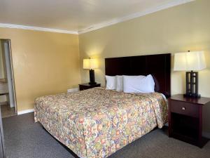 a hotel room with a large bed with two lamps at Economy Motel in Galloway